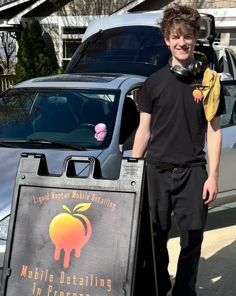 John beside his Liquid Nectar Mobile Detailing sign